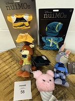 Photo showing Disney nuiMOs dolls Nick Wilde and Judy Hopps with two carded outfits and a pink fuzzy ice cream cone Wishable plush.