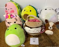 Seven Squishmallows plush collection showing variety of characters and colors, some with attached tags