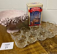 Photo showing all items: 8 clear glass punch bowl cups in a row, rectangular Cracker Jack collectible tin, and pink floral decorated pedestal centerpiece bowl.
