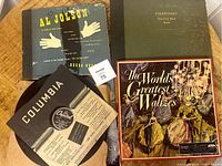 Five vinyl records shown, some in their original sleeves with vintage cover art. Al Jolson record with Decca label, Strauss waltzes, and Stravinsky recording visible.