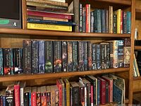 Wide view of bookshelves showing various book titles, mainly novels and historical books.