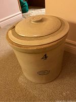 Photo of entire large beige Medalta stoneware crock with lid stamped No. 4, showing maker's mark.