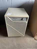 Front view of beige Simplicity 15 dehumidifier showing control dial and vent design.