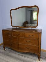 Overall view of the dresser and attached mirror showing shape, color and condition.