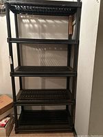 Front view of the black plastic utility shelving unit showing all five shelves.