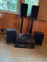 Full view of stereo components including ONKYO CD player and tuner/amplifier, four PSB speakers, two speaker stands, and cords.