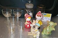 Overall view of lot showing glassware and assorted figurines including Christmas dolls and green bear salt shaker