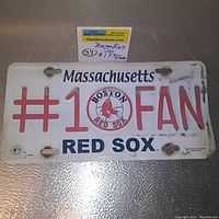 Photo of the full vintage Massachusetts #1 FAN Boston Red Sox car plate showing details, wear and rust spots.
