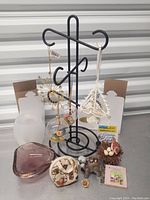 Photo showing the full lot of collectibles including the glass bowl, ornaments, small purse, figurines and book.