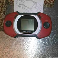 Single red T28 handheld game player shown powered off with 11 games, directional pad, buttons, and screen.