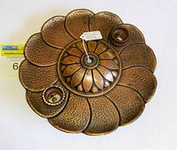 Top-down view of vintage copper floral light fixture showing central dome and two bulb sockets