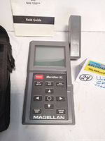 Photo of Magellan Meridian XL GPS device, showing the front with screen, keypad, and detachable antenna next to it.