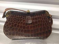 Front and slight angle view of the Vintage SHAW handbag showing the leather texture, clasp, strap, and metal corners.