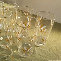 Top angle of 8 vintage Libby wheat spray tumblers with gold rim showing the painted wheat design and glass clarity.