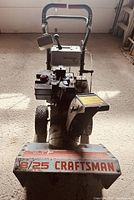 Front view of Craftsman 8/25 snowblower showing control handle, engine, and chute.