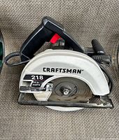 Close-up of Craftsman circular saw model 218 with grey casing and black handle, showing blade and label.
