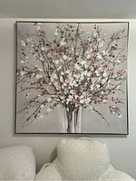 Front view of large square cherry blossom canvas painting hung on the wall above a white textured chair.