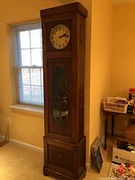 Full front view of oak grandfather clock showing overall design