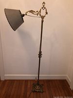 Full-height view of lamp showing base, column, adjustable arm, and shade