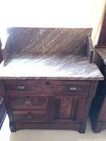 Full front view showing marble top, backsplash, drawers and cabinet door