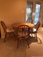 Full view of round drop leaf table with four chairs in room