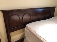 Full view of Ethan Allen mahogany king size headboard attached to mattress and box springs.