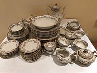 Full set layout showing multiple stacks of plates, bowls, cups, saucers, coffee pot, creamer, sugar bowl, gravy boat, serving pieces