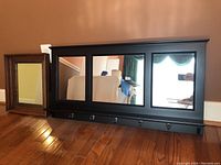 Both mirrors shown side by side on hardwood floor near brown wall and electrical outlet for scale.