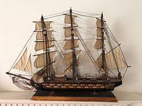 Full side view of the 1780 Spanish frigate model ship showing three main masts, detailed sails, rigging, and cannons along the hull.