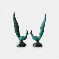 Pair of Danesi Arts pottery roadrunner figurines with tall tail feathers, shown from the front on white background.