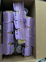 Photo of multiple purple ceramic jumbo and super jumbo hot roller clips inside a box