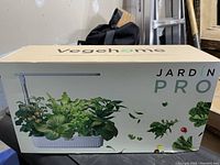 Box front showing Vegehome Jardin Pro hydroponic indoor garden system with images of leafy greens growing under an LED light.