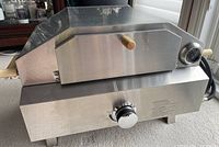 Front view of oven closed showing control knob and thermometer gauge