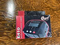 Photo of the Cort E410 Auto Chromatic Tuner original box showing the front with the product image and branding.