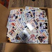 Box filled with hundreds of hockey cards with various players and teams shown on card fronts.