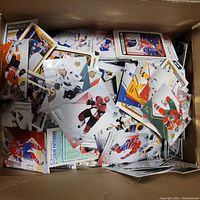 Photo shows a box filled with a large number of assorted hockey cards from various teams and players.