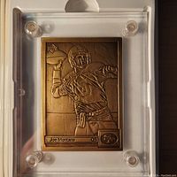 Front side of bronze card with embossed image of Joe Montana throwing a pass, includes Upper Deck and 49ers logo, name and position.