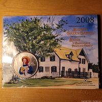 Front image of the coin in its display card with artwork of Green Gables house and text.