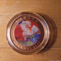 Close-up photo of the 2011 Canadian 50 cent coin showing a colored lenticular image of Santa Claus reading a list in a protective case.