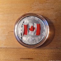 Front of 2015 Canadian silver coin showing coloured Canadian flag and inscription of purity and value