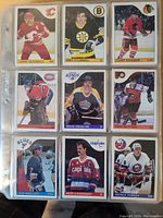 Nine hockey cards displayed in a protective plastic sleeve, featuring players from Calgary Flames, Boston Bruins, Chicago Black Hawks, Montreal Canadiens, Los Angeles Kings, Philadelphia Flyers, St. Louis Blues, Washington Capitals, and New York Islanders.