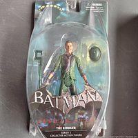 The Riddler figure clearly visible inside damaged blister pack with Batman Arkham City branding.