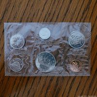 Front side view of first plastic panel with six 1968 Canadian uncirculated coins including penny, nickel, dime, quarter, half dollar, and one cent coins.