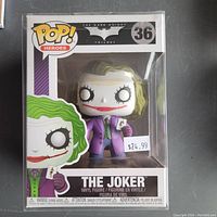 Front view of Funko Pop The Joker #36 in original packaging showing character design and retail price sticker.
