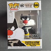 Front view of the box showing Sylvester as Batman figure inside, clear window packaging, Funko Pop Animation and DC Looney Tunes branding, figure number 844 with FYE exclusive sticker.