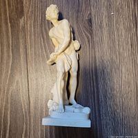 Full view of Santini sculpture of David standing on a rectangular base, holding a sling, detailed muscular figure, ivory-toned material.
