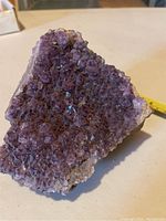 Close-up of amethyst cluster showing dense purple crystals with a rough base.