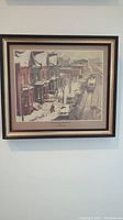 Framed artwork on a wall showing a snowy street scene in Toronto with houses and a streetcar.