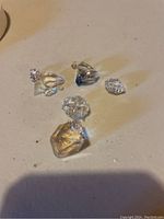 Six clear quartz crystals arranged on flat light-colored surface