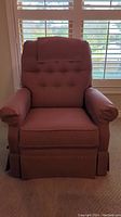 Front view of pink fabric Lazyboy rocker recliner chair with button-tufted backrest and fabric headrest cover.